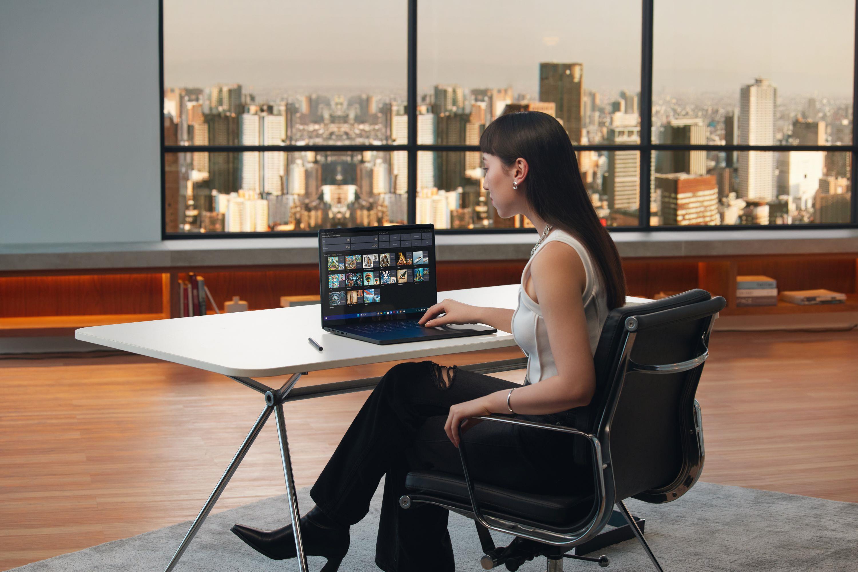 A woman sitting at a desk with an ASUS laptop